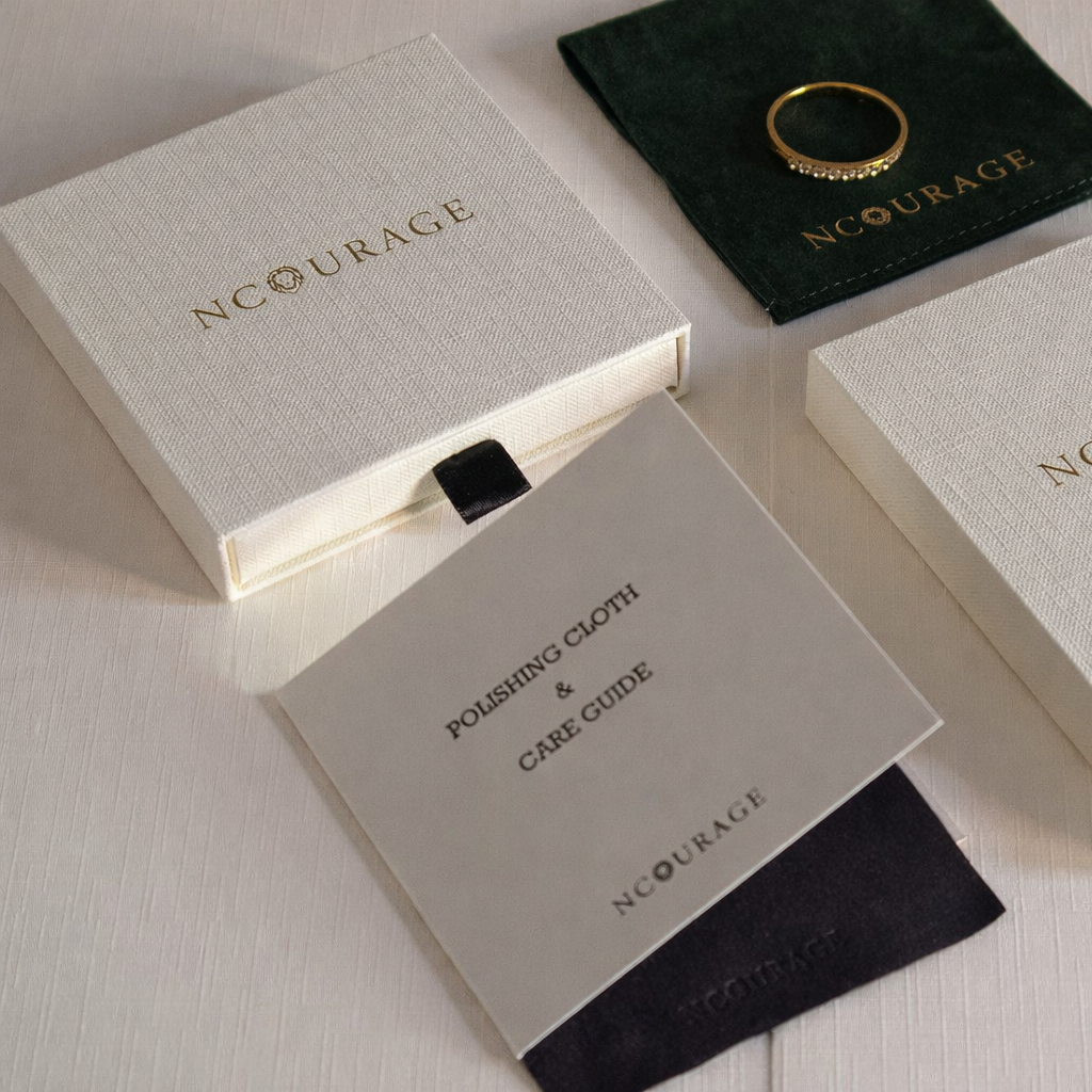 Jewelry set with 'ncourage' branding on packaging and accessories.