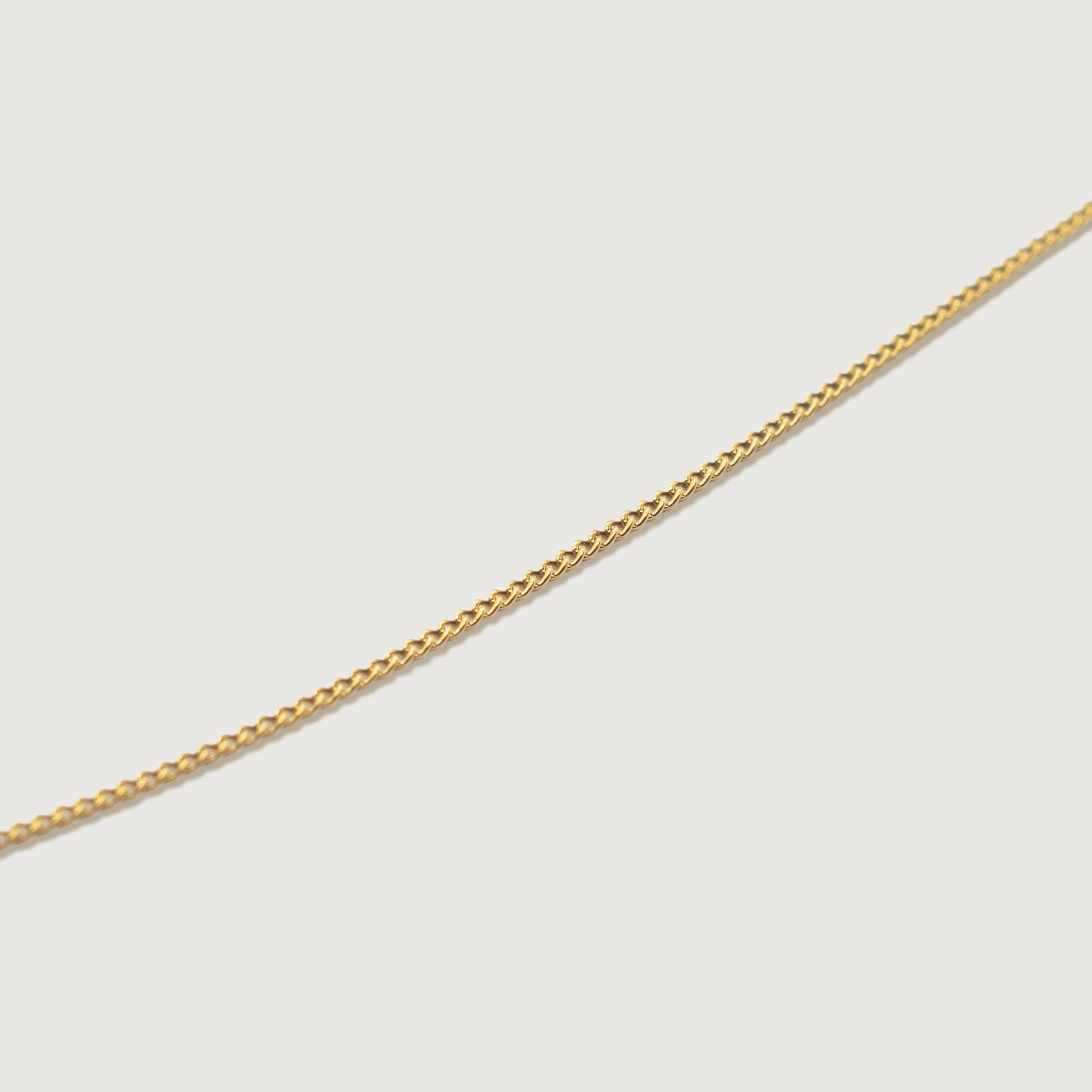 Up close detailed view of the adjustable dainty cable necklace, highlighting its sleek silhouette and delicate finish.